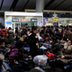 A train station worker uses a speaker phone to alert Chinese travelers to board their trains in Beijing on Jan. 31.